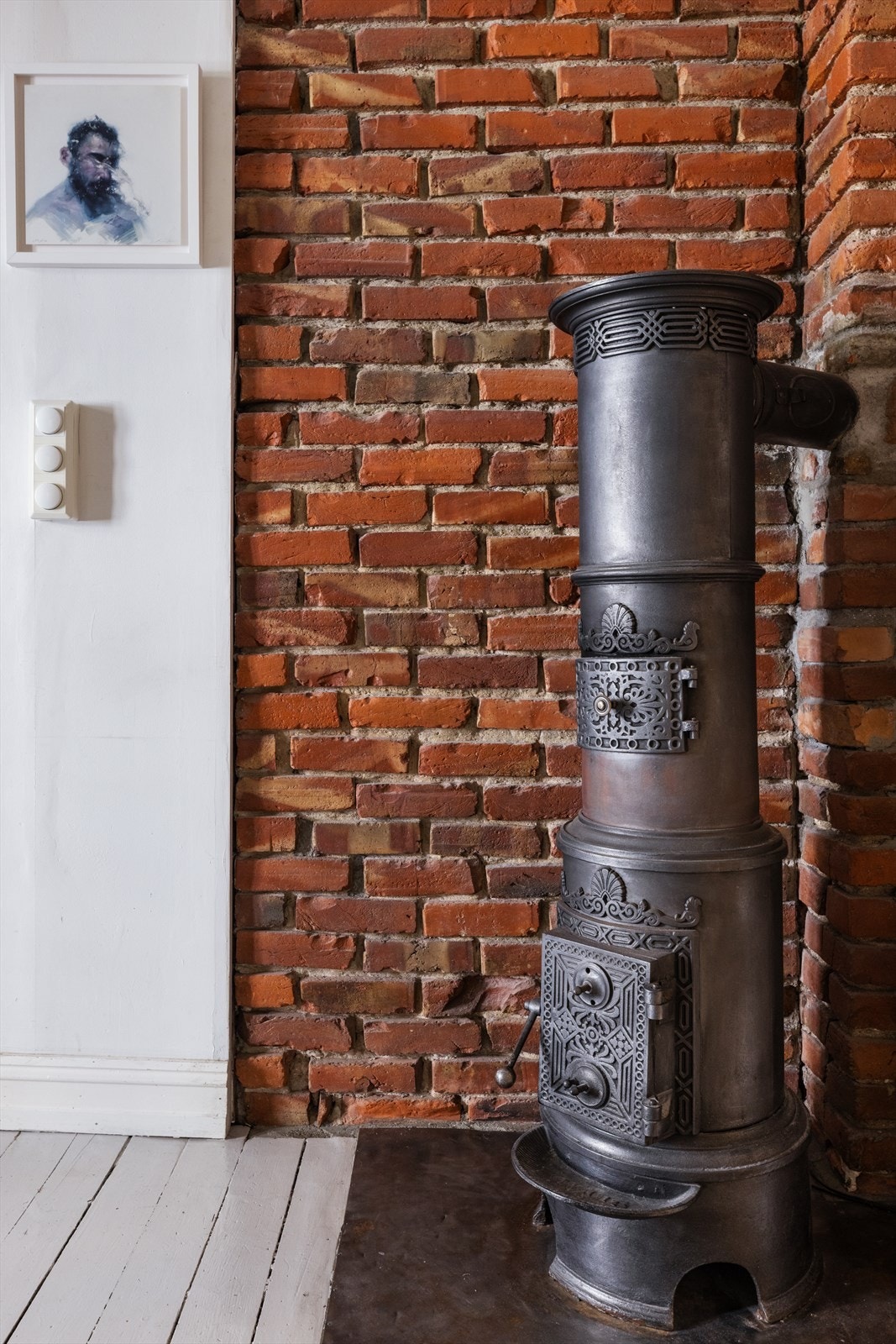 Den originale støpejernsovnen og teglsteingsveggen, gir et flott særpreg på leiligheten. Galleribilde