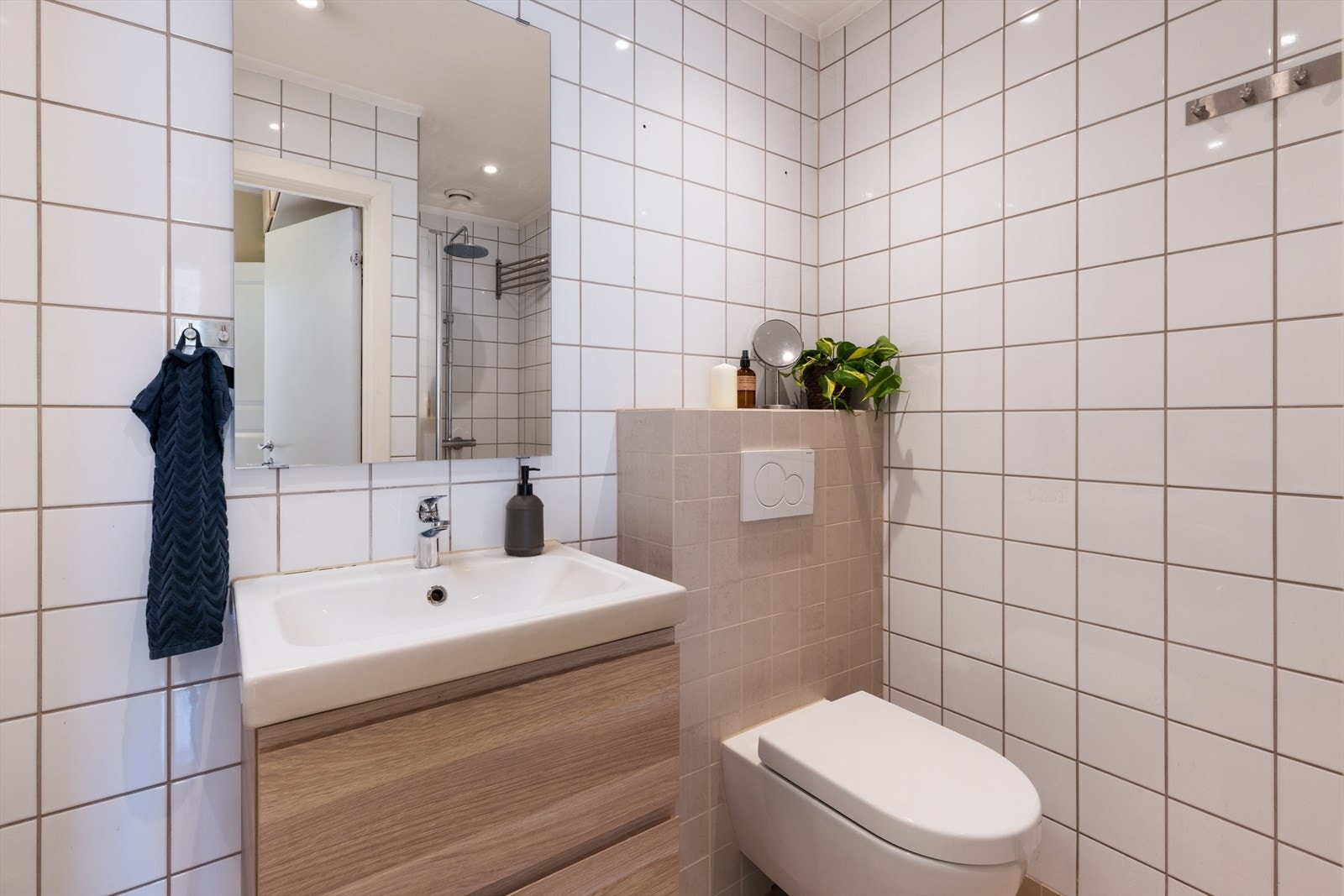 Pent, tidløst bad med flislagte overflater, gulvvarme og downlights i himling. Galleribilde