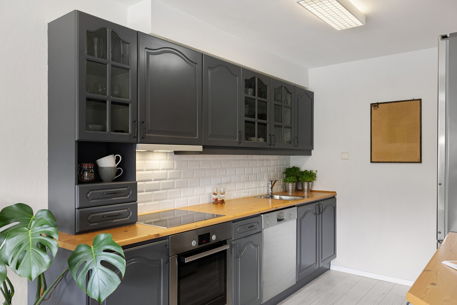 Kjøkkenet har en lun og sjarmerende stil, med profilerte fronter i mørk grå tone og laminert benkeplate som gir et tidløst og varmt uttrykk. Galleribilde