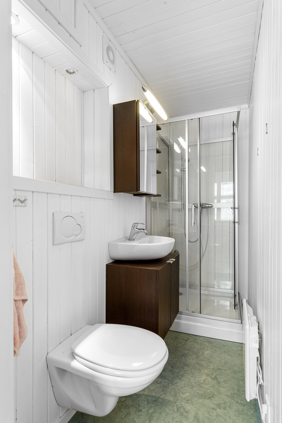 Badet er utstyrt med innredning med servant, vegghengt toalett og dusjkabinett. Galleribilde