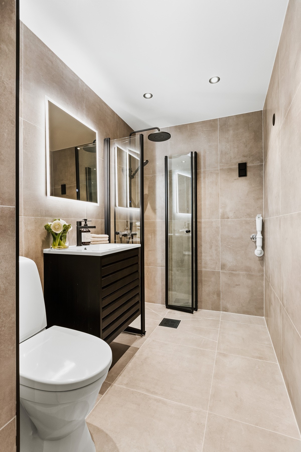 Rålekkert baderom, oppusset i 2025 med nye fliser, innredning, dusj, armaturer og opplegg for vaskemaskin. Galleribilde