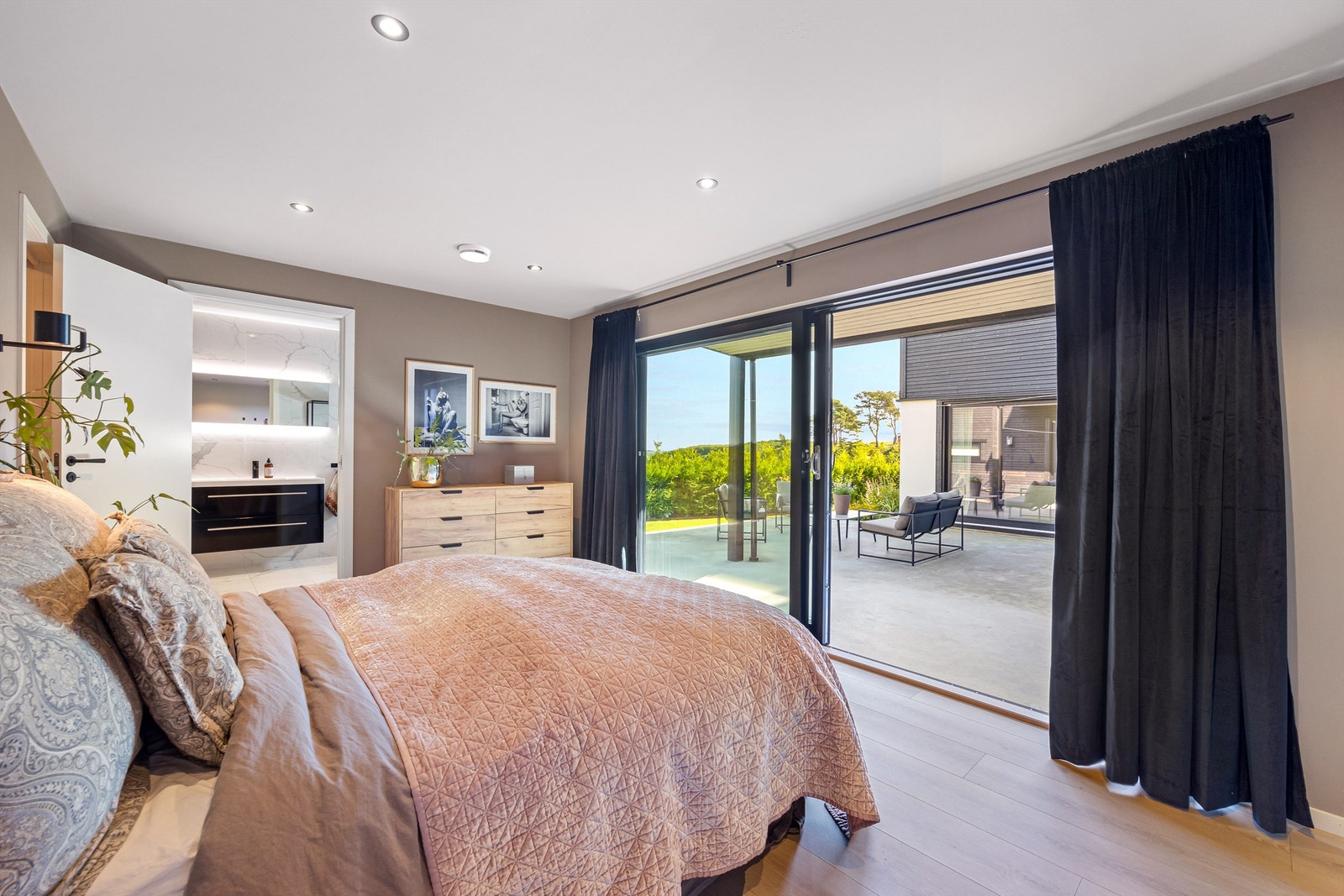 Stort soverom i 1 etasje med tilhørende bad, 2 garderoberom og egen utgang til hagen. Galleribilde