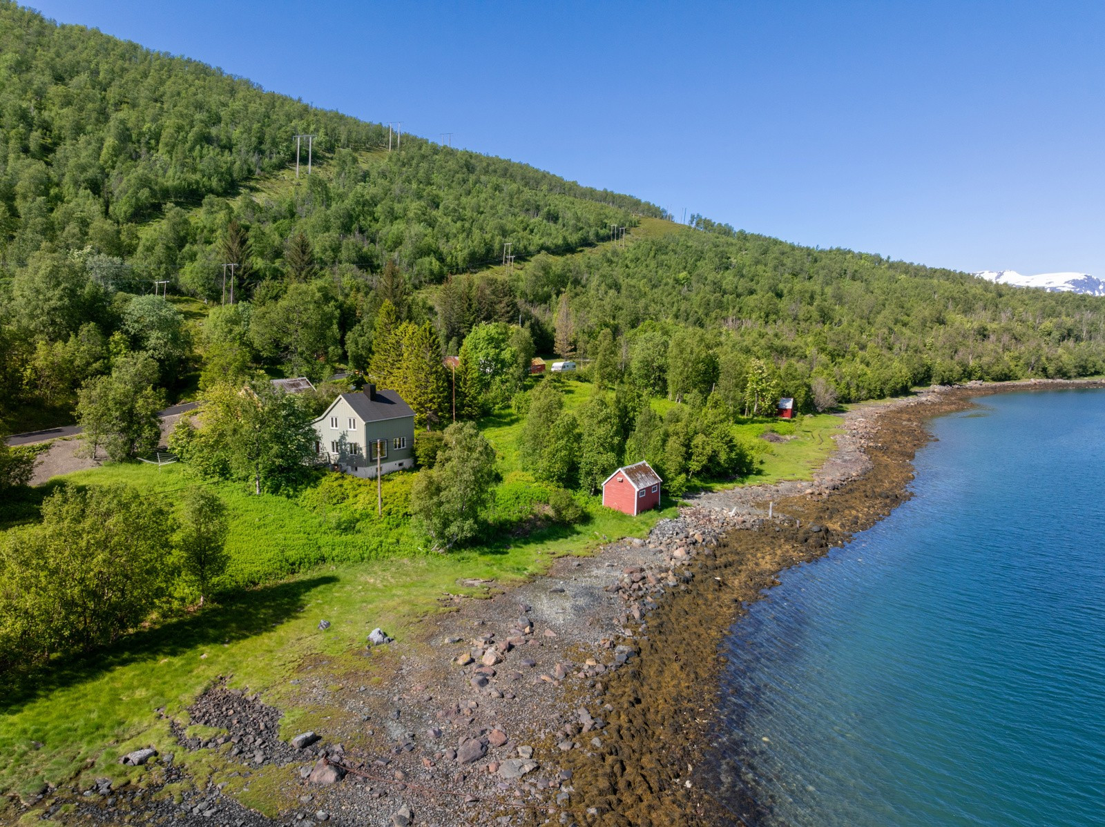 Strandlinje med naust og båtstø.