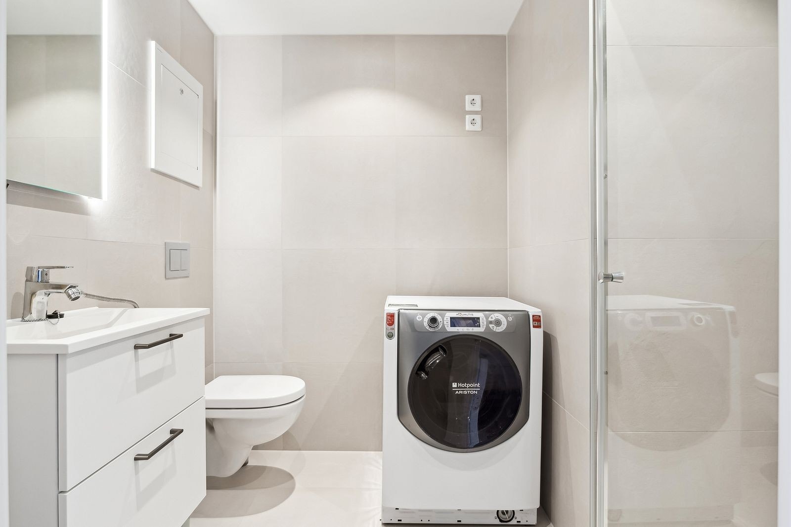 Badet har lekre kvaliteter og er innredet med dusj, servant, vegghengt toalett og vaskemaskin Galleribilde