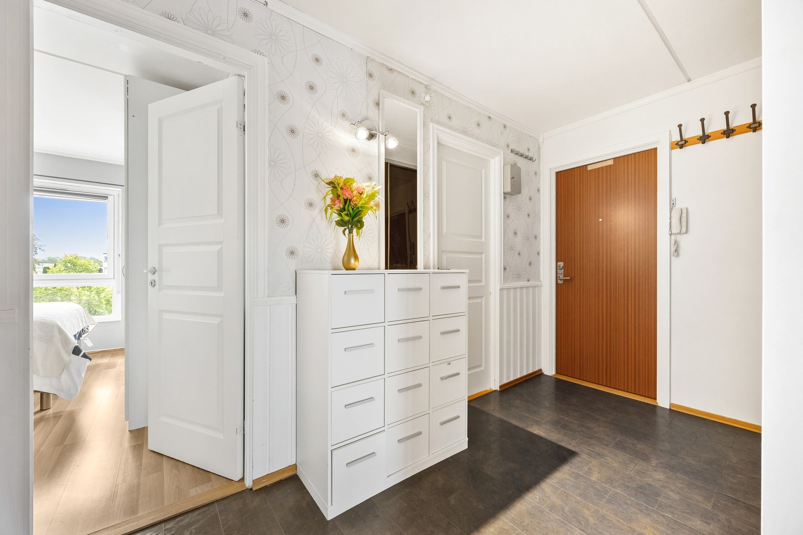 Entréen fungerer som et praktisk knutepunkt for flere av rommene i leiligheten. Galleribilde