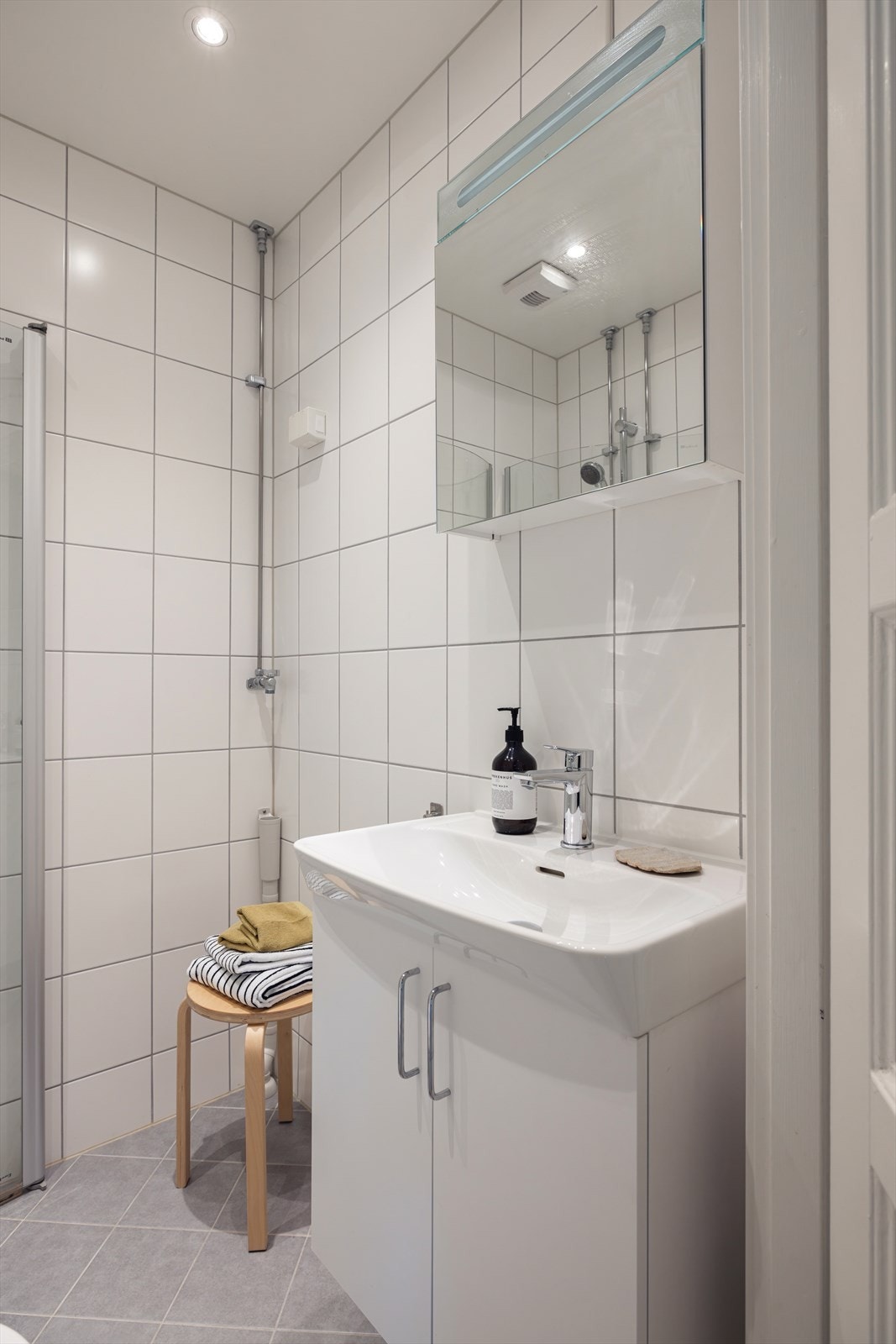 Badet er innredet med vegghengt toalett, servant (Ny i 2024) og dusjhjørne med svingbare dører. Opplegg for vaskemaskin. Galleribilde