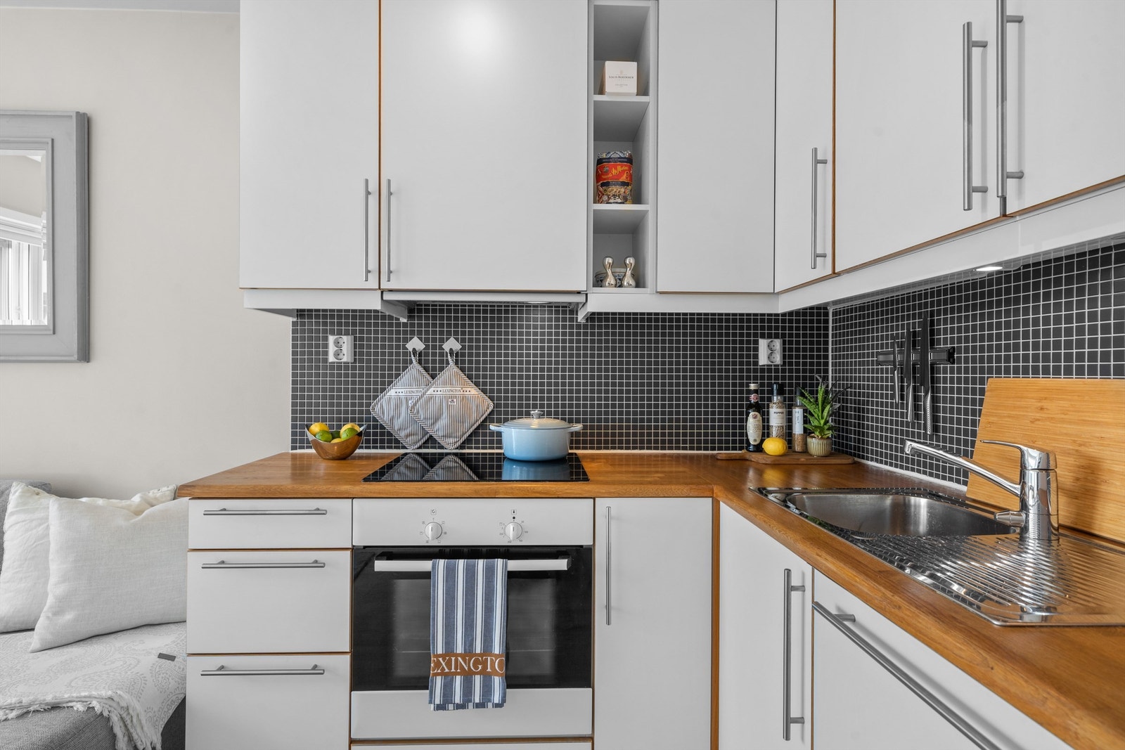 Kjøkkeninnredning fra byggeår med slette fronter i hvit utførelse og benkeplater av tre. Galleribilde