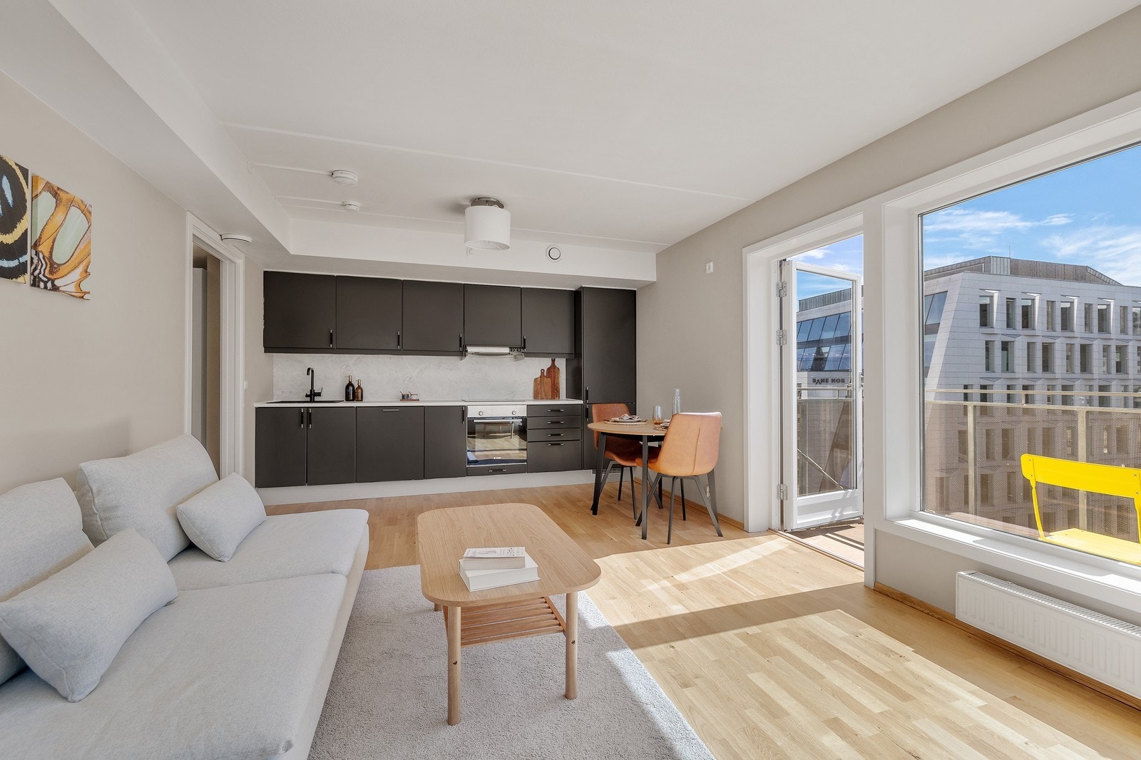 Stuen ligger i åpen løsning med et kjøkken i mørke detaljer. Galleribilde