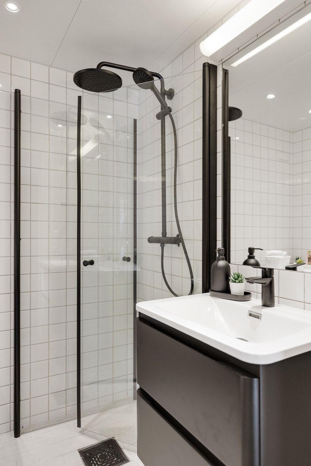 Baderommet er innredet med dusjhørne med innfellbare dører og vegghengt servantskap med skuffer. Galleribilde