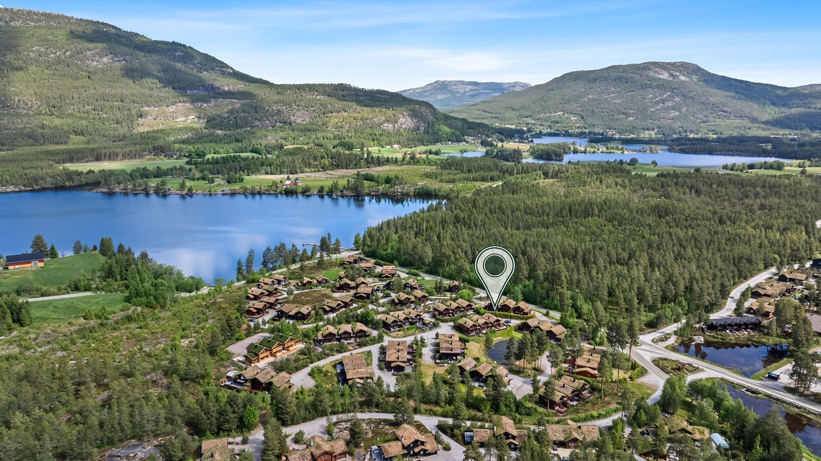 Hytten ligger sentralt og solrikt til. Her har man fint utsyn til omkringliggende fjell og til et koselig tun på fellesareal. Idyllisk med et lite vann midt på felles eiet tomt og med naturlig vegetasjon omkring. Galleribilde