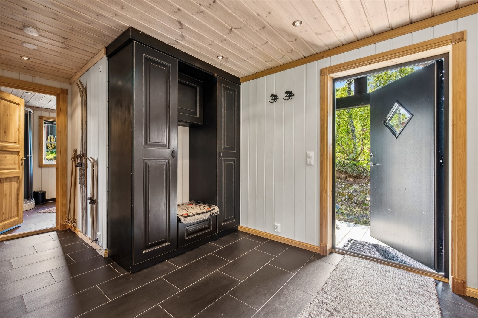 Du ønskes velkommen av en romslig entré med flislagt gulv, som gir et innbydende preg. Her er det god plass til å henge fra seg yttertøy og sko i garderobeskap. Galleribilde