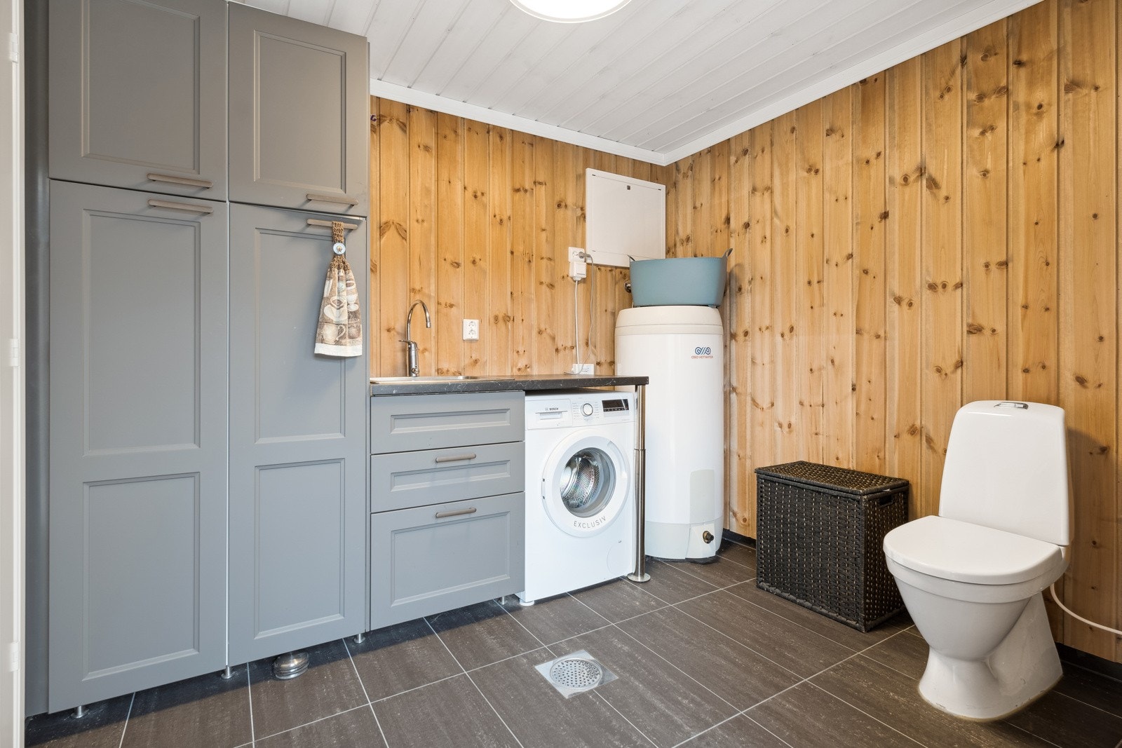 Praktisk vaskerom på 6,6m² med innredning, wc, varmtvannsbereder samt opplegg og plass for vaskemaskin Galleribilde