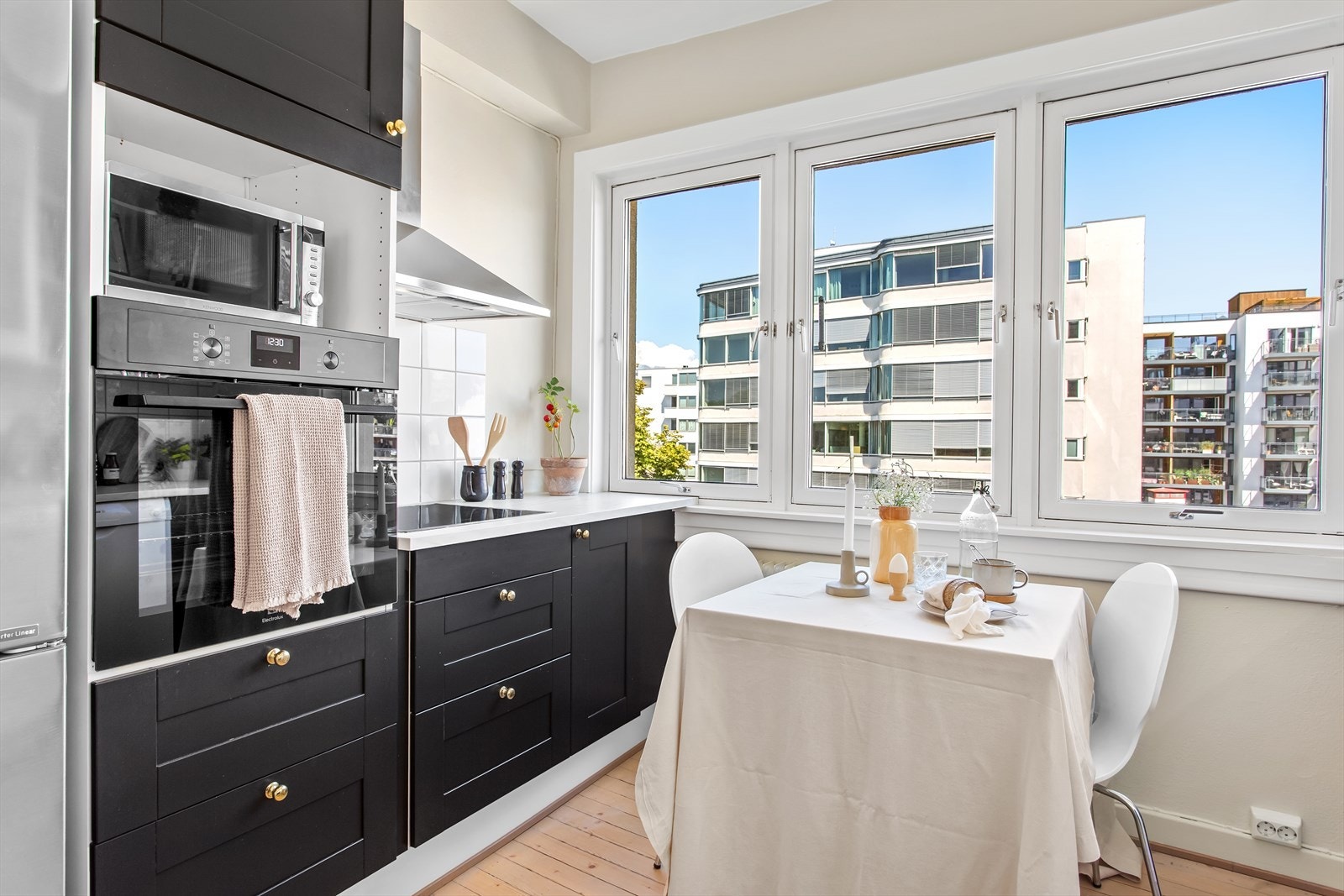 Kjøkkenet er av god størrelse, har store vindusflater og plass til kjøkkenbord Galleribilde