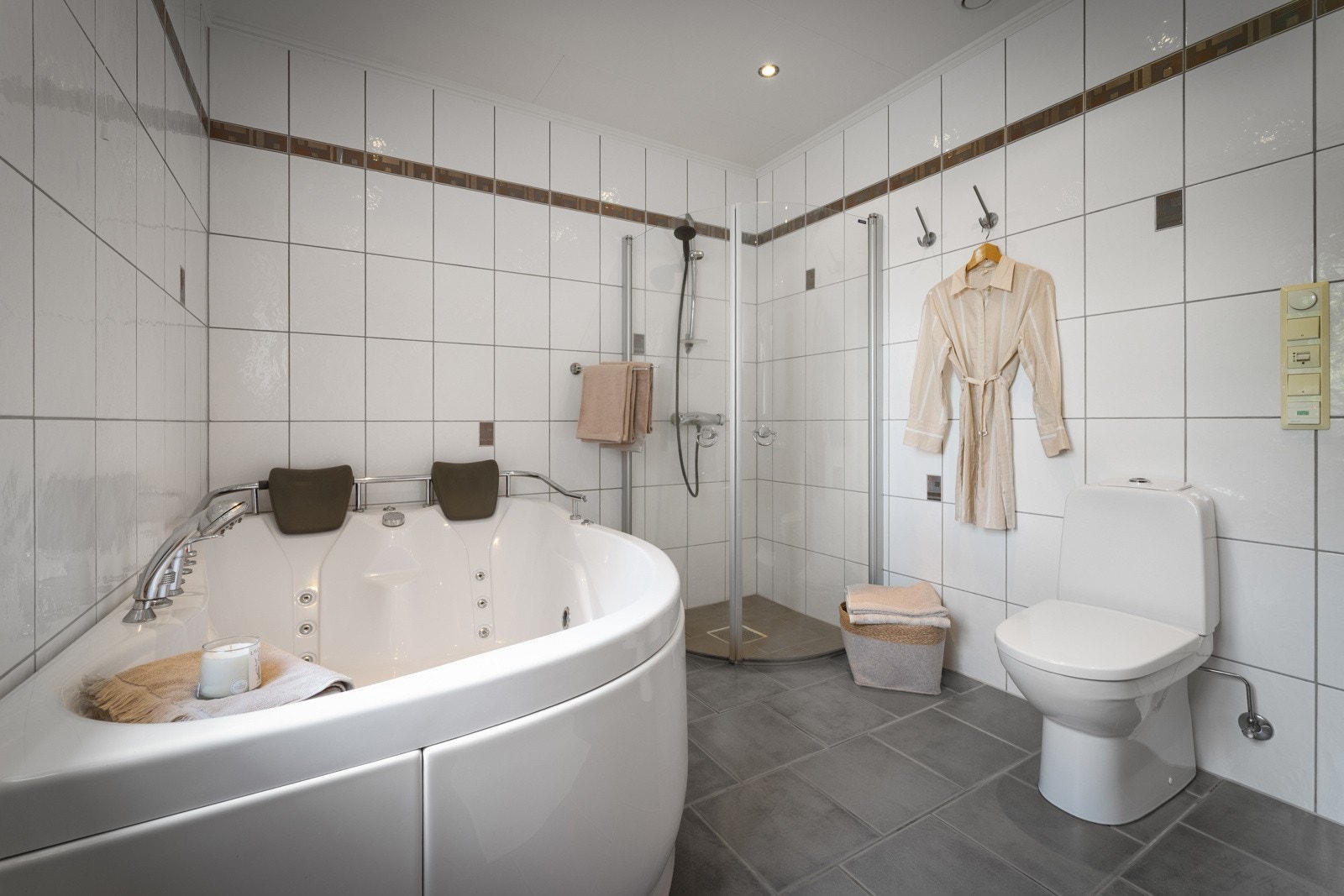 Badet holder god størrelse og er innredet med både badekar og dusjhjørne Galleribilde