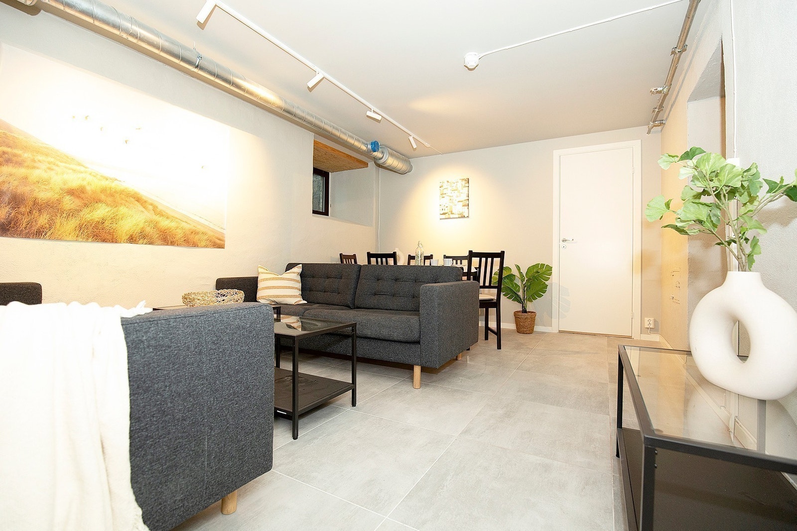 Stue møblert med sofa, sofabord, TV benk og spisestue Galleribilde