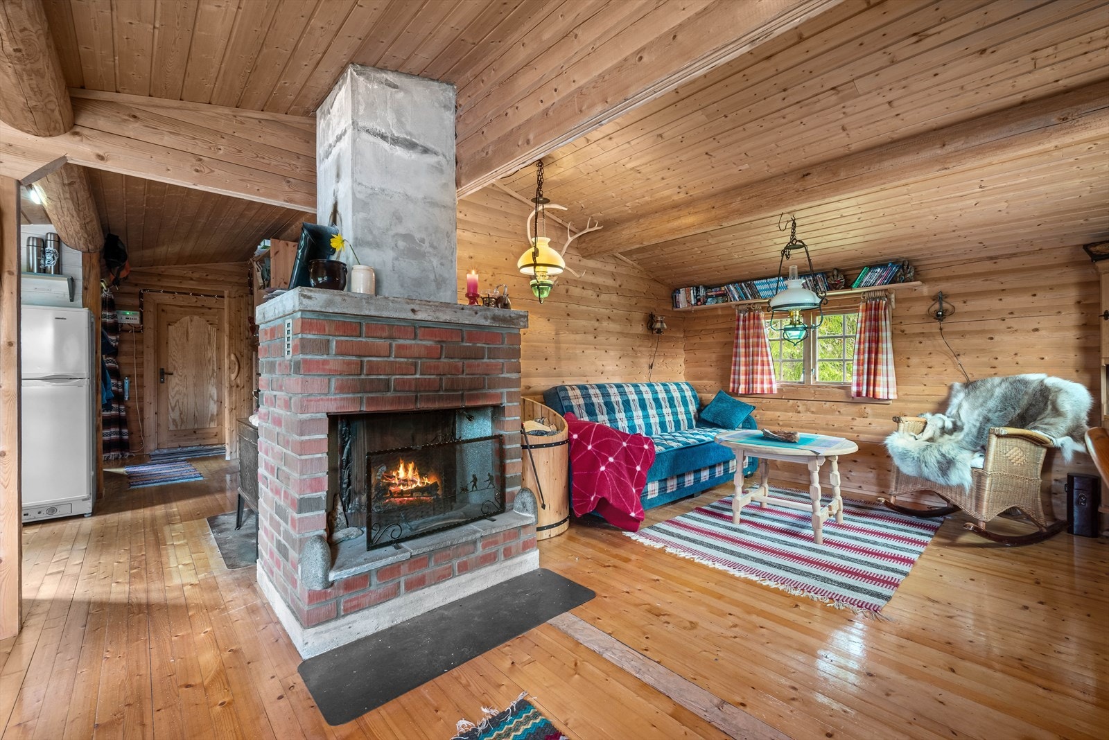 Koselig peis midt i stuen som gjør hytta god og varm. Galleribilde