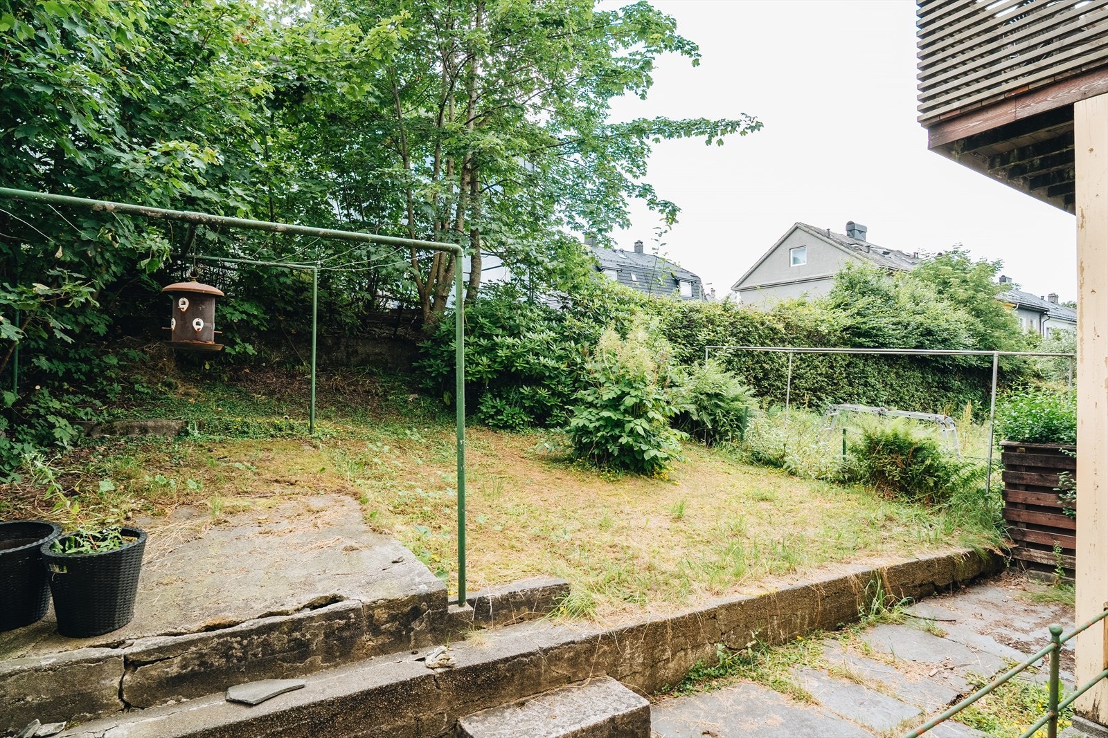 I bakgården ligger en usjenert hage med både gressplen, trær og platting. Et rolig og grønt pusterom midt i byen - perfekt for avslapning, små hagestunder eller hyggelige måltider ute. Galleribilde