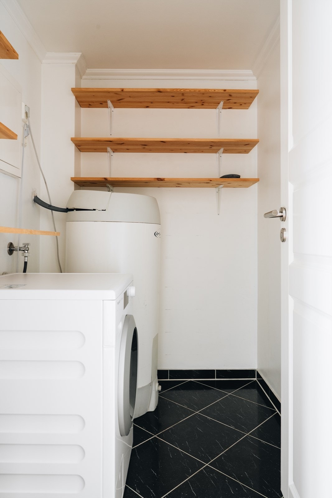 Et eget vaskerom i hoveddelen gjør hverdagen enklere. Rommet har opplegg for vaskemaskin og varmtvannsbereder, og er helfliset med praktisk beliggenhet rett innenfor gangen. Galleribilde