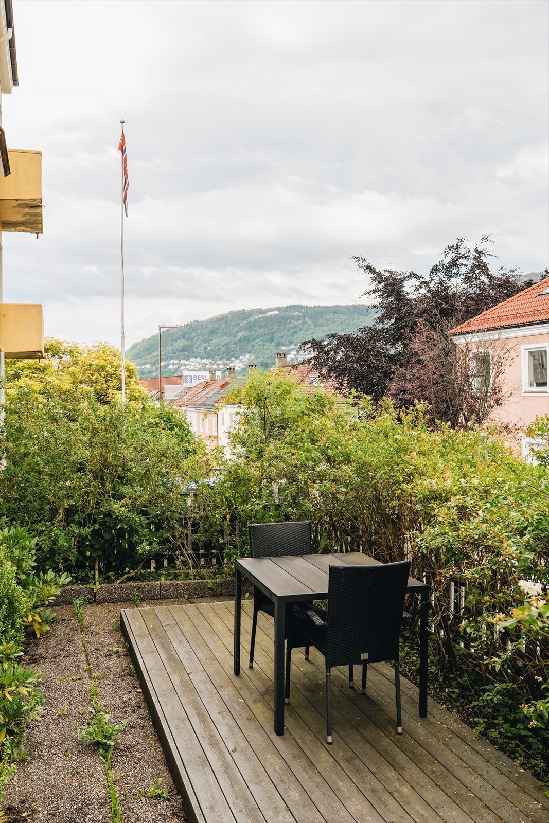 Foran huset finner du en liten platting som gir plass til sittegruppe og blomsterpotter - en hyggelig velkomstsone med morgenlys. Galleribilde