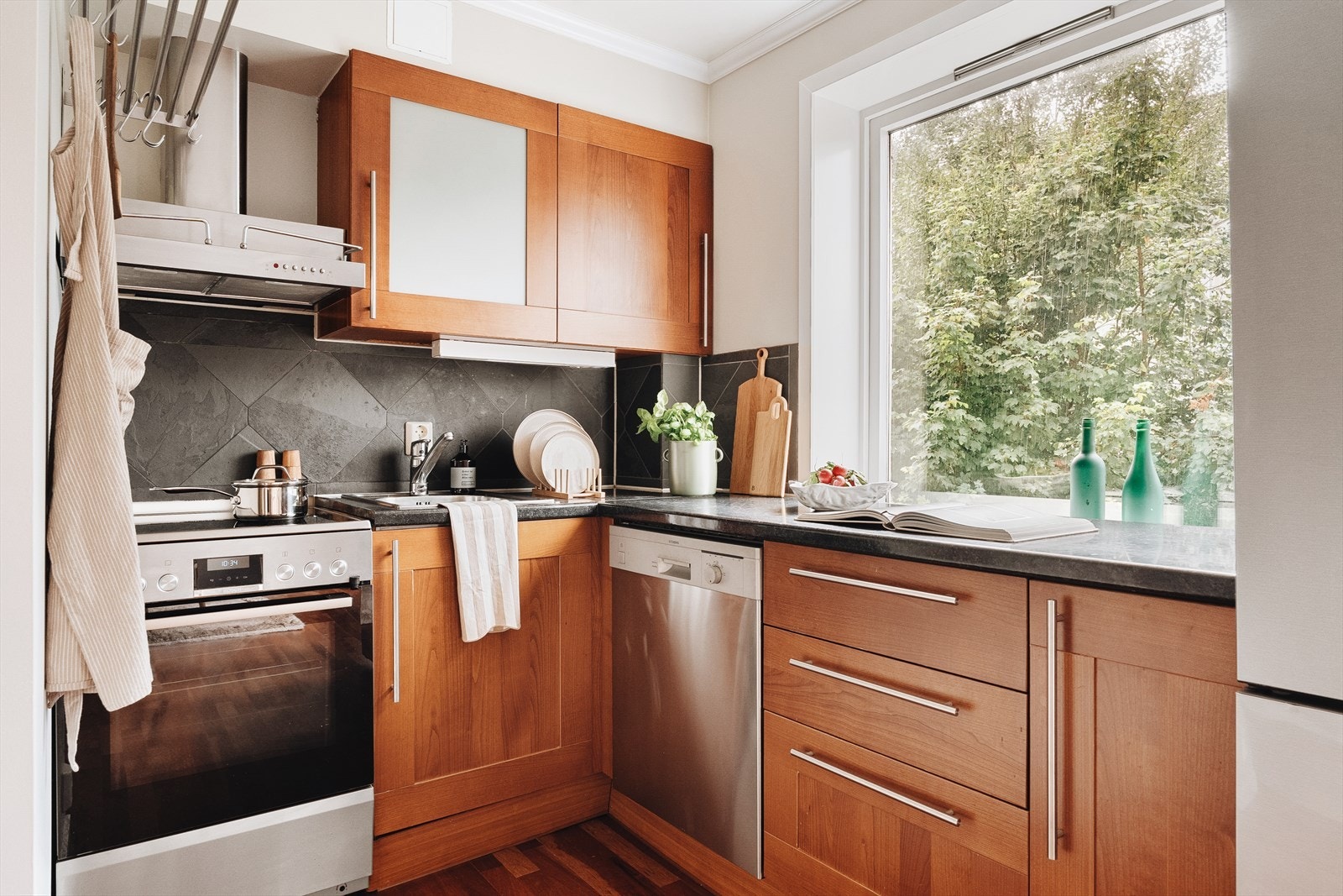 Kjøkkenet har italiensk designinnredning i mørk kirsebærfarge, og kombinerer praktiske løsninger med tidløs stil. Kjøkkenet er åpent mot stue og spisestue og skaper god flyt i rommet. Galleribilde