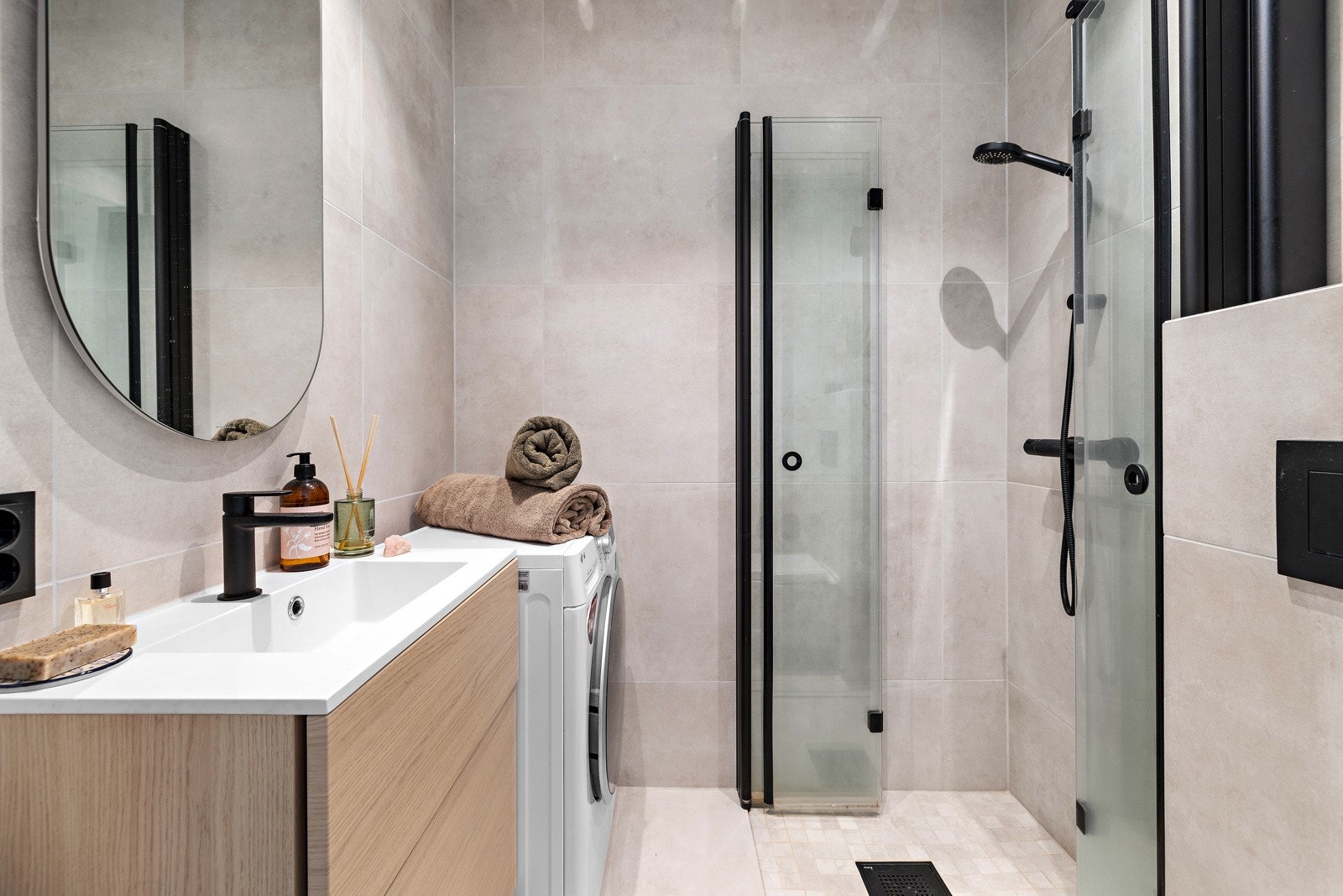 Delikat flislagt baderom oppusset i 2023. Opplegg for vaskemaskin og tørketrommel. Galleribilde