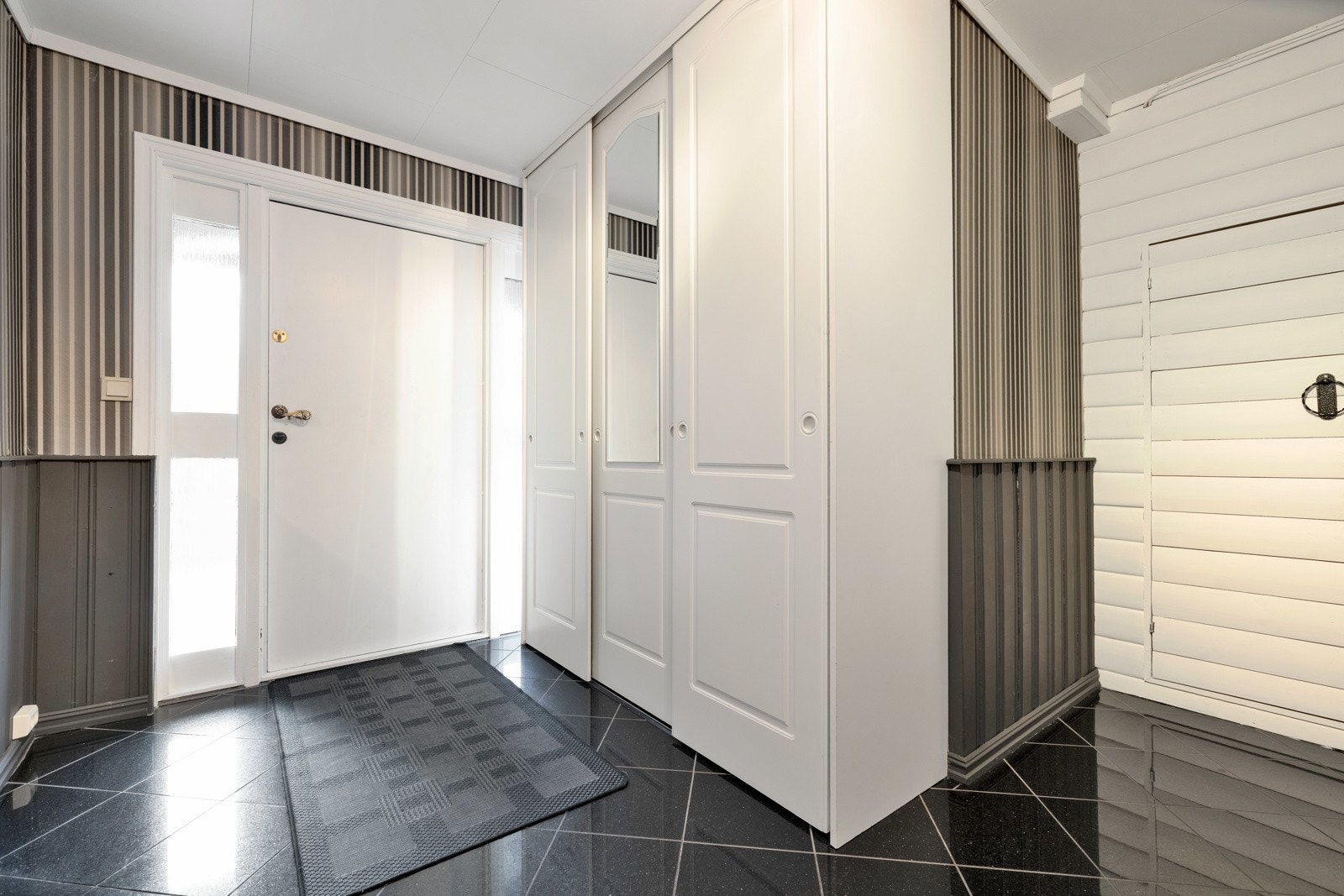 Lys og romslig entré med fliser på gulv Galleribilde