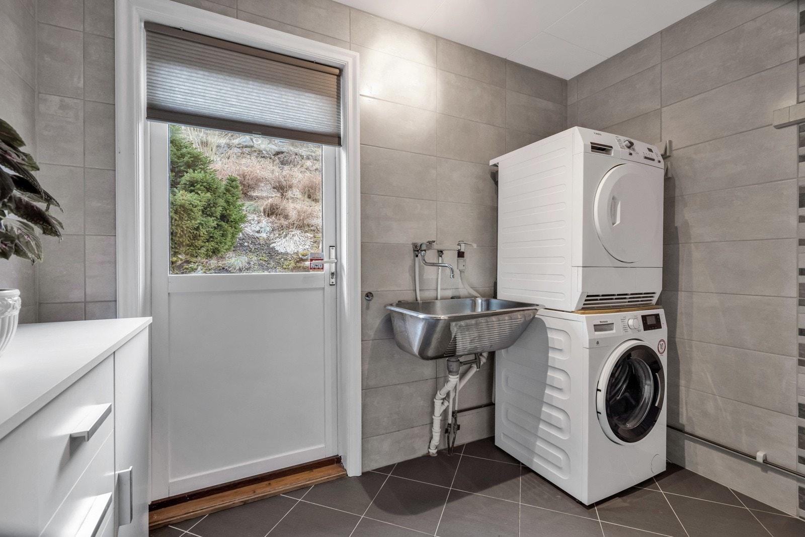 Praktisk vaskerom i samme etasje med opplegg til vaskemaskin og utslagsvask Galleribilde