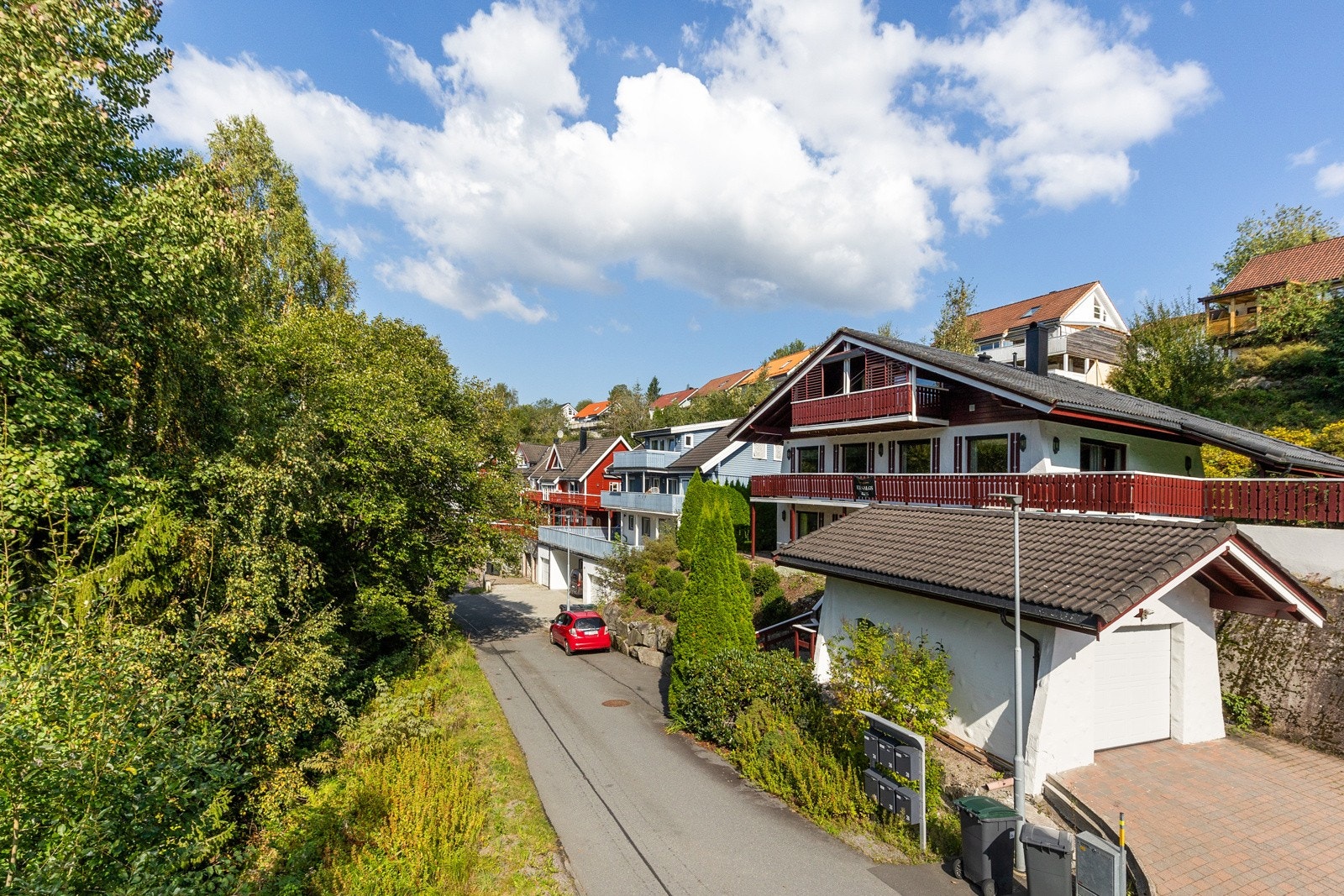 Enkel garasje i samme utførelse som boligen med elektrisk leddport samt plass til flere biler utenfor Galleribilde