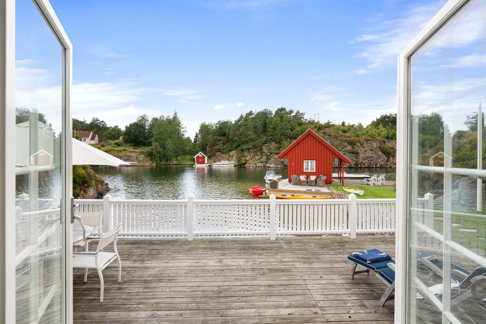 Fra stuen går man rett ut på en stor solterrrasse med sandstrand utenfor Galleribilde