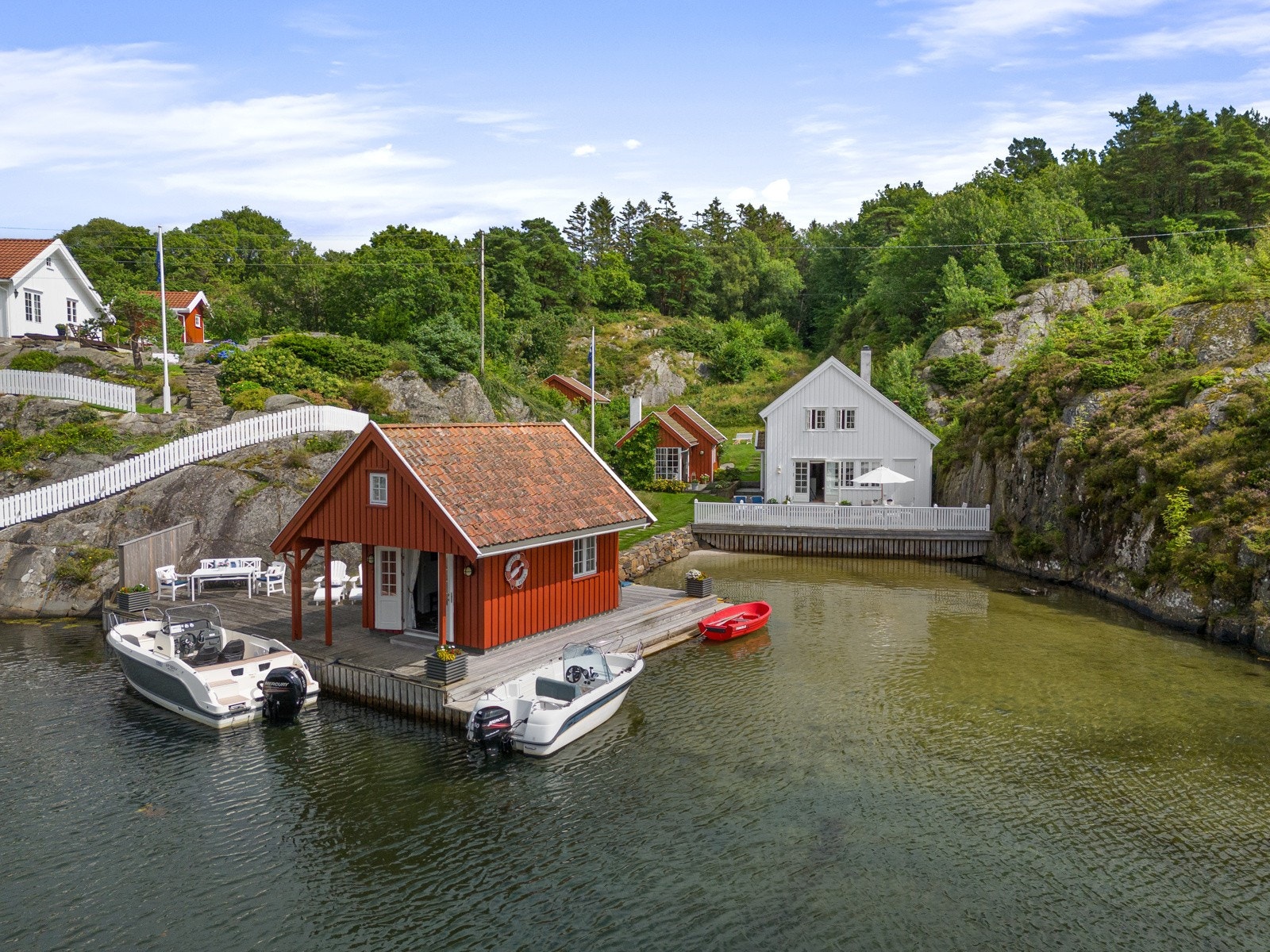 Sjøbua i front - og hytten fint plassert inne i bukten Galleribilde
