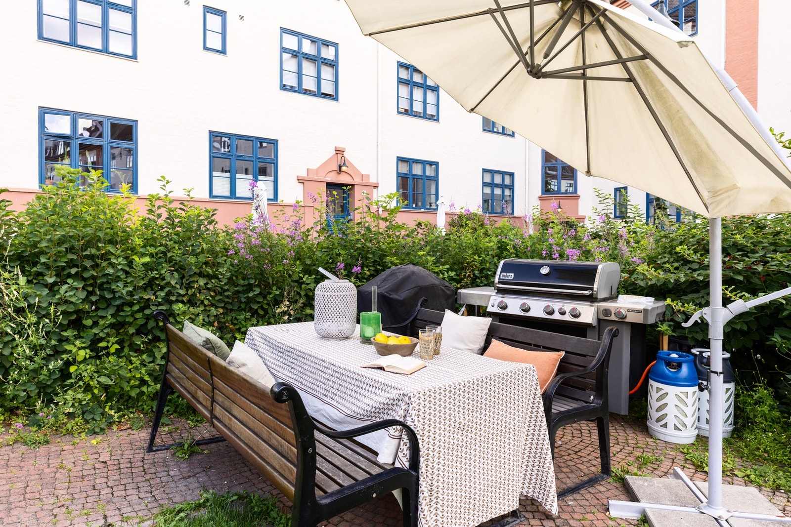 En rekke sittegrupper, grill, pizzaovn, grøntområder og beplatning. Galleribilde