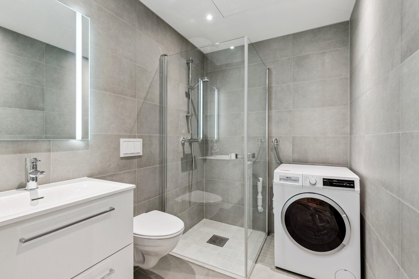 Flislagt baderom med opplegg for vaskemaskin. Galleribilde