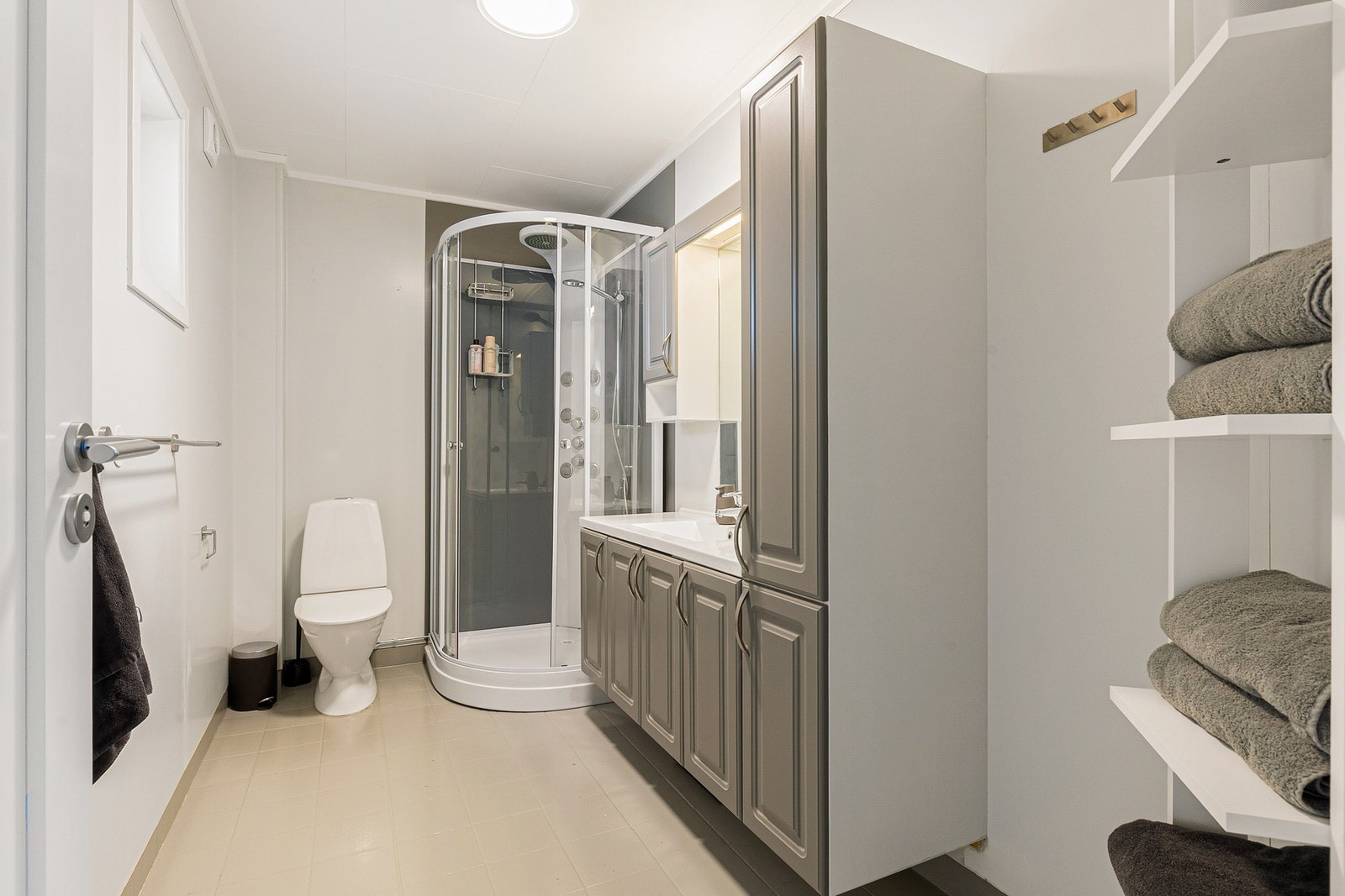 Baderommet er bestående av servant med underskap, dusjkabinett og toalett Galleribilde