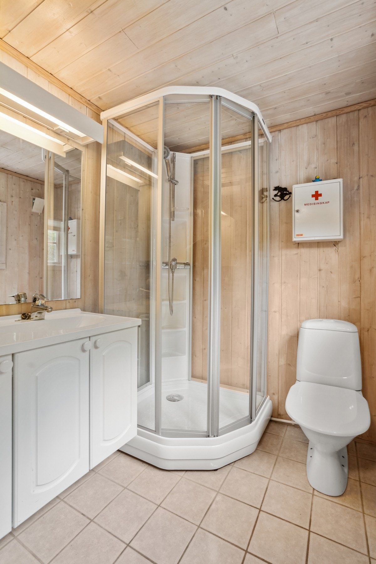 Her er det utstyrt med baderomsmøbel med overliggende speil m/belysning, toalett og dusjkabinett. Galleribilde