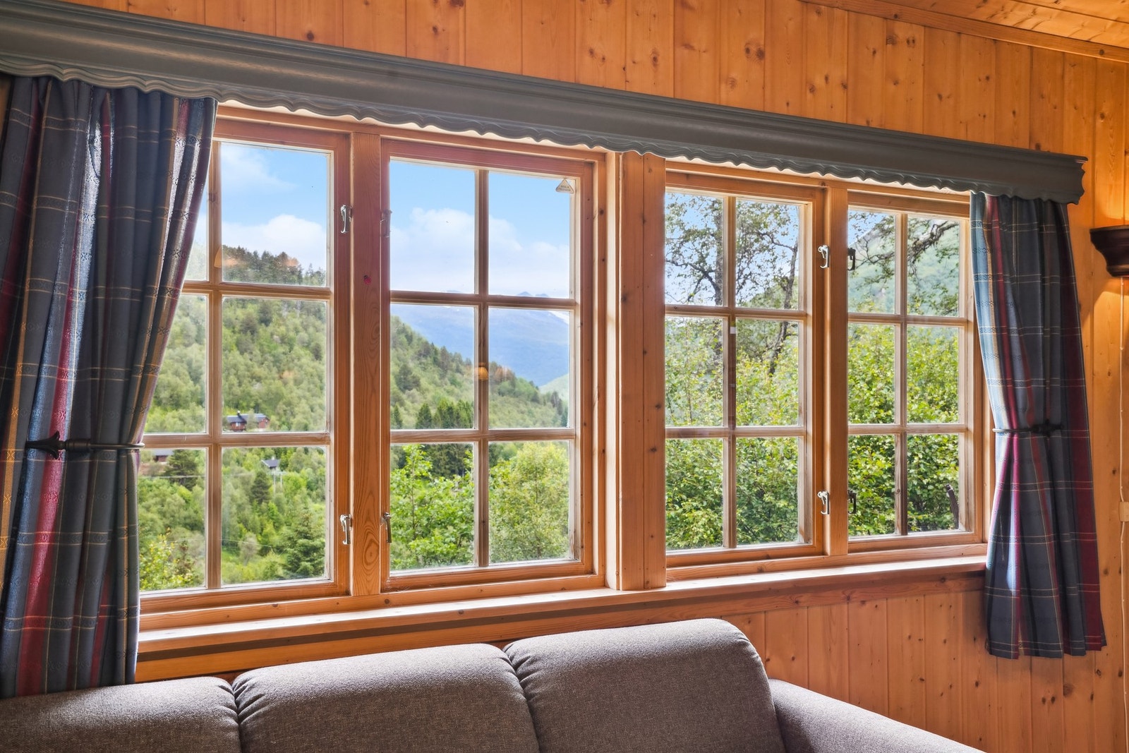 I stuen får man en luftig romfølelse med et godt lysinnslipp fra de store vindusflatene - disse bevarer også den frodige utsikten. Galleribilde