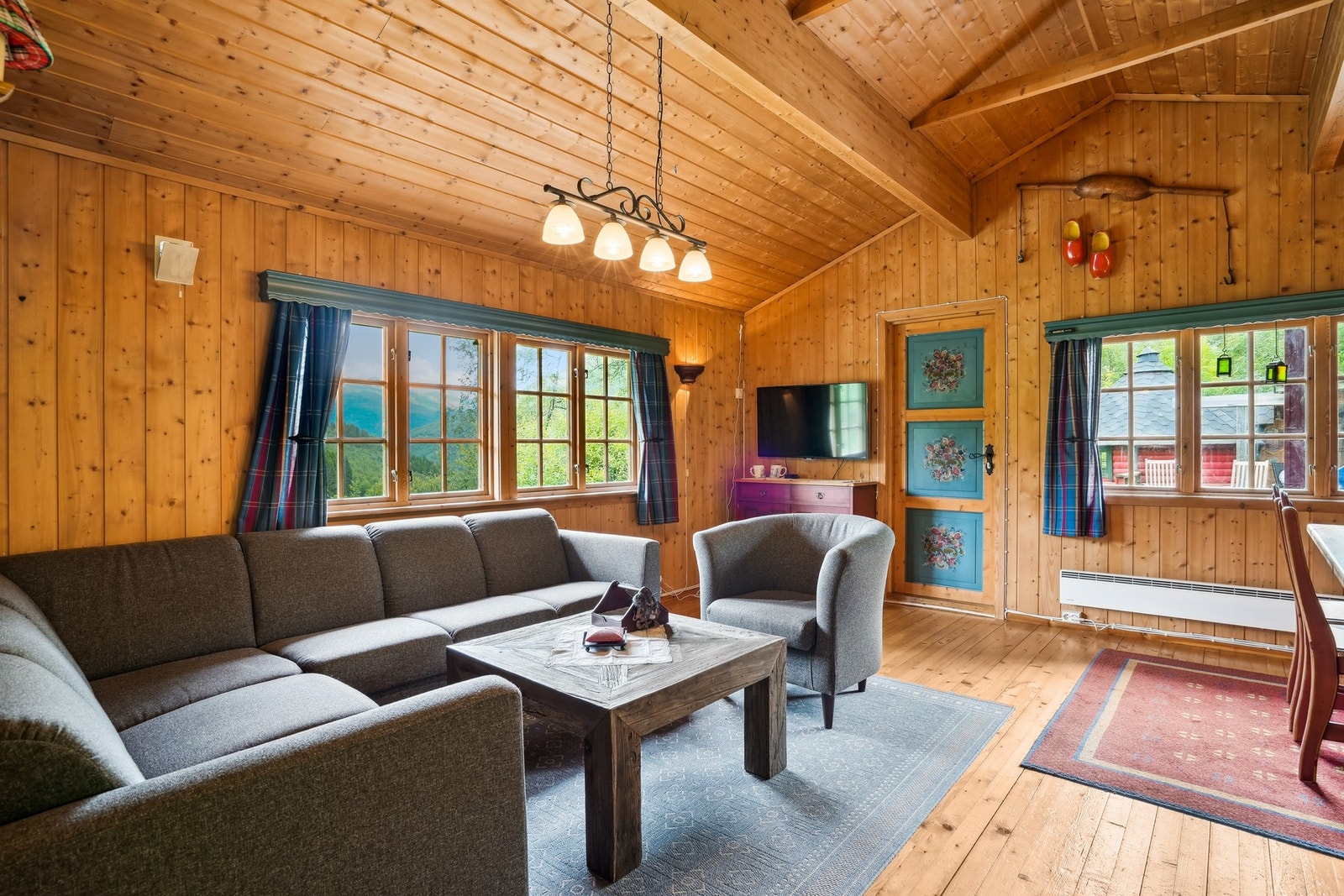 Hytten har sjarmerende detaljer som et flott furugulv og profilerte dører med tradisjonelle malerier. Galleribilde