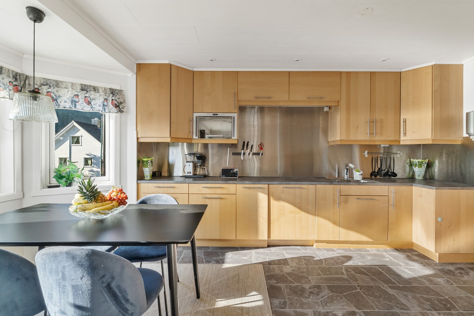 Pen kjøkken med takhøy innredning og integrerte hvitevarer. Galleribilde