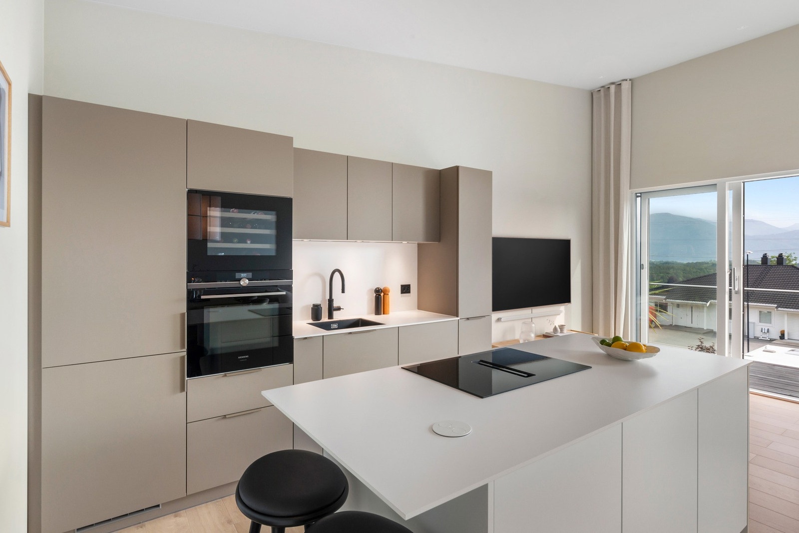 Det tidsriktige kjøkkenet er levert av KVIK. Integrerte hvitevarer som kjøl/frys, koketopp, vinskap, oppvaskmaskin og stekeovn. Galleribilde