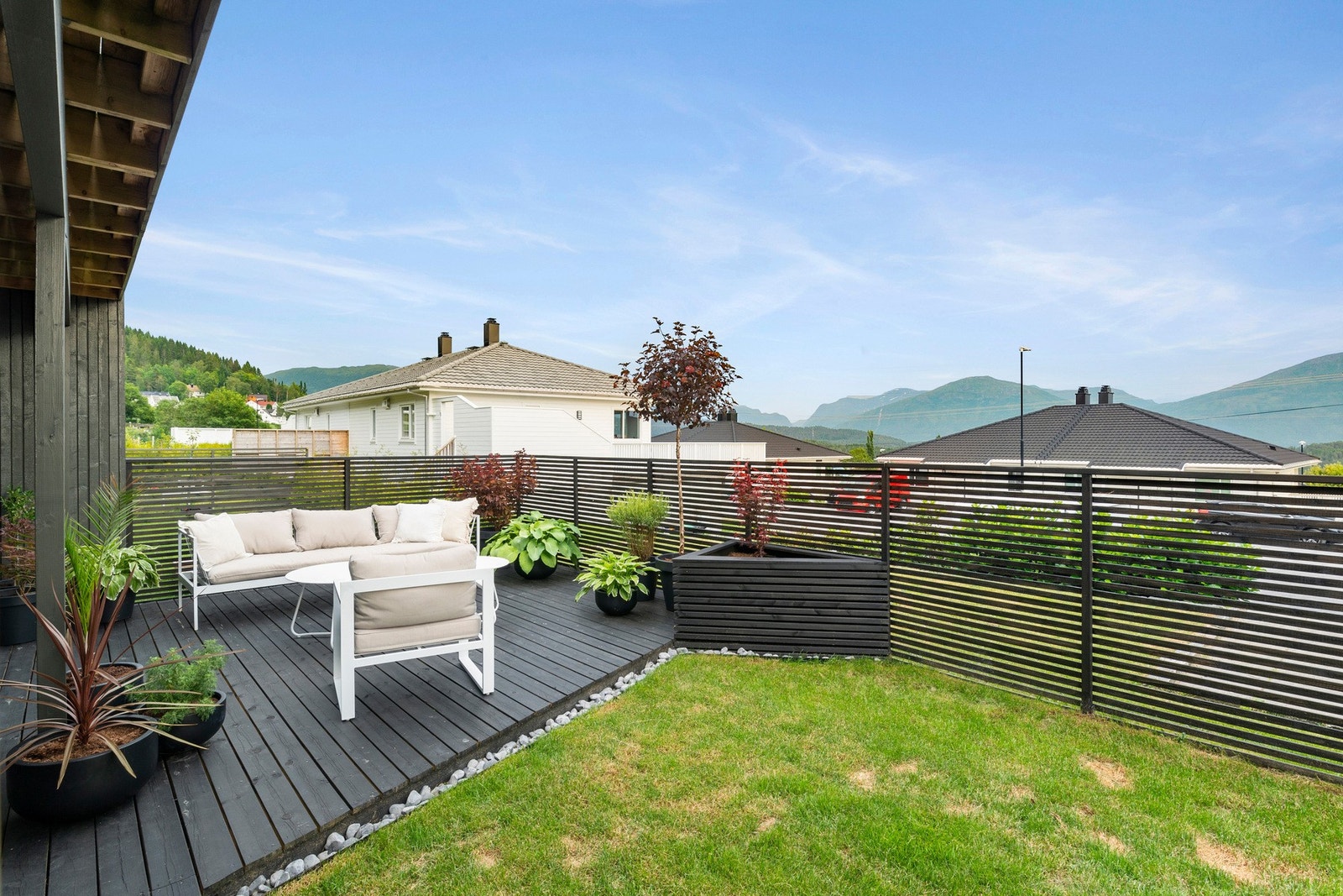 Legg merke til den flotte detaljen med steinsatt designlinje ved terrasse og blomsterkasse. Galleribilde