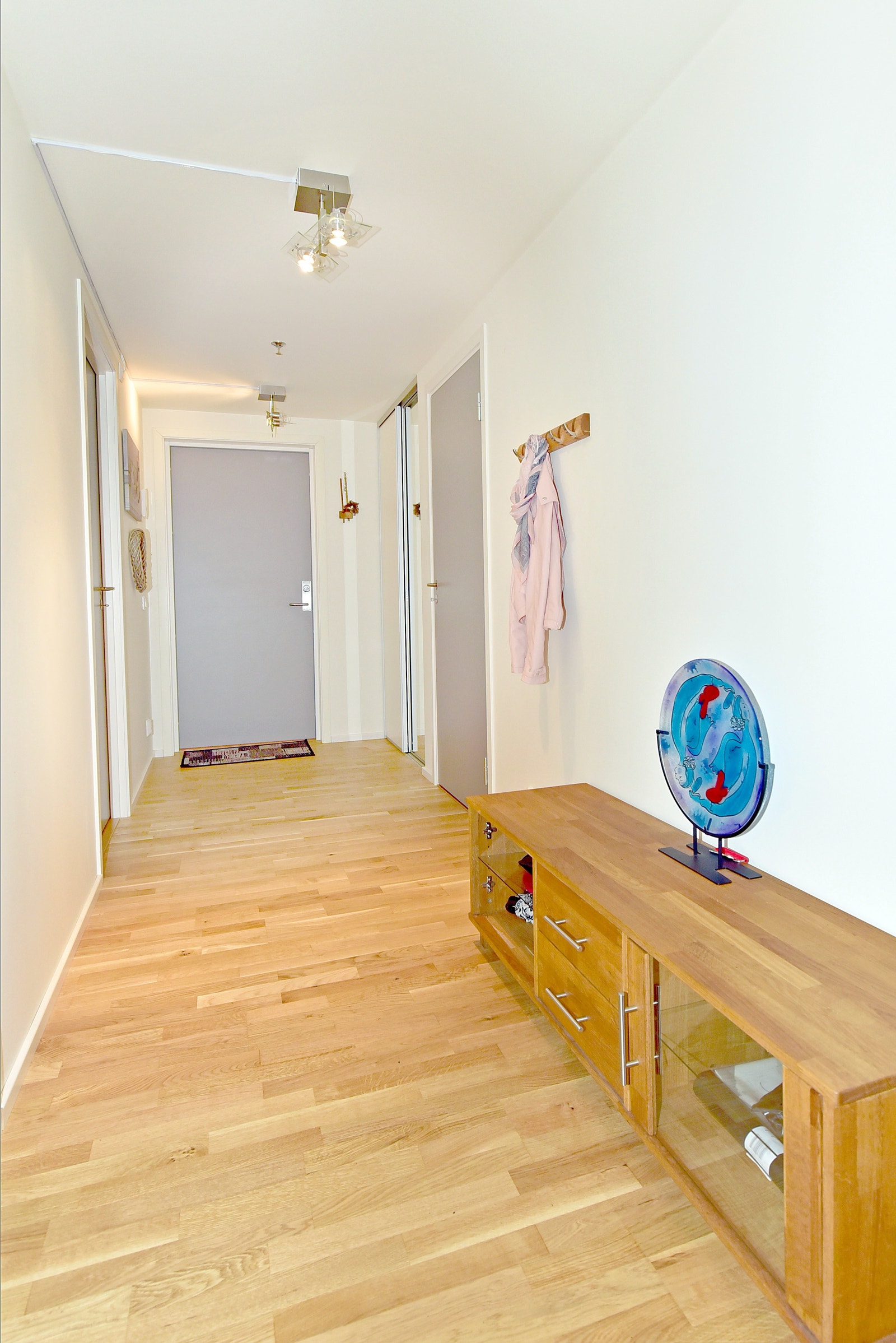 Innendørs gang med skyvedørsgarderobe og tilgang til tre soverom og innendørs bod. Innendørs bod har fryser og hyllesystem Galleribilde