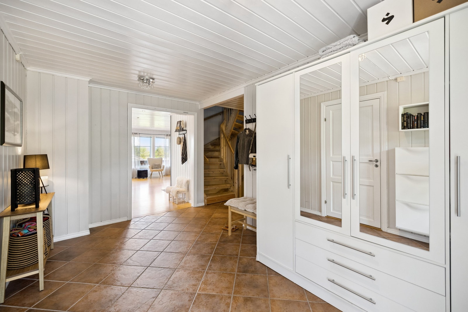 Boligens hovedinngang ligger i 1. etasje, med et overbygget inngangsparti på ca. 3m². Man kommer inn gjennom en laminert ytterdør med glassfelt og et sidefelt i glass, som slipper inn lys. Galleribilde