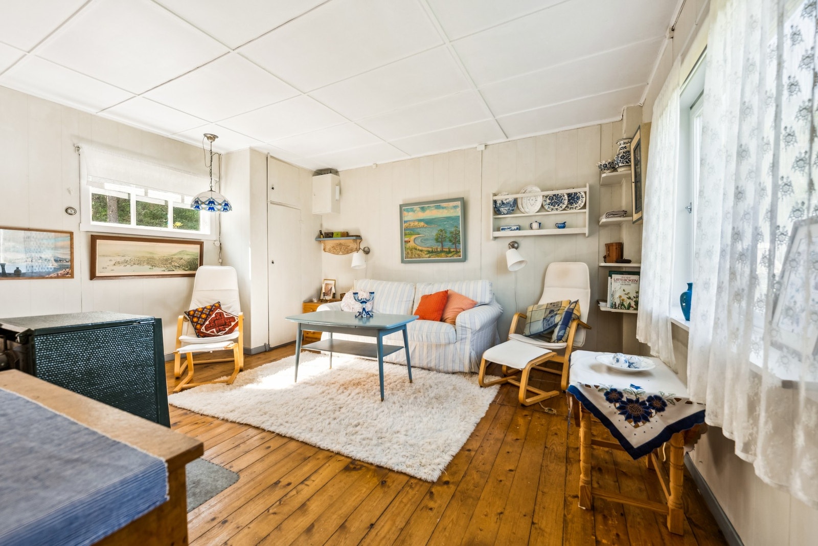 Romslig stue med store vindusflater mot sjøen. Galleribilde