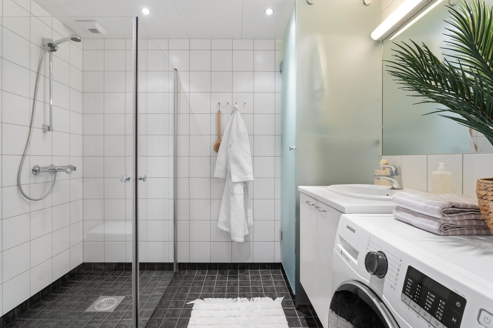 Pent bad med flislagte vegger og gulv med gulvvarme og malt himling med downlights. Galleribilde