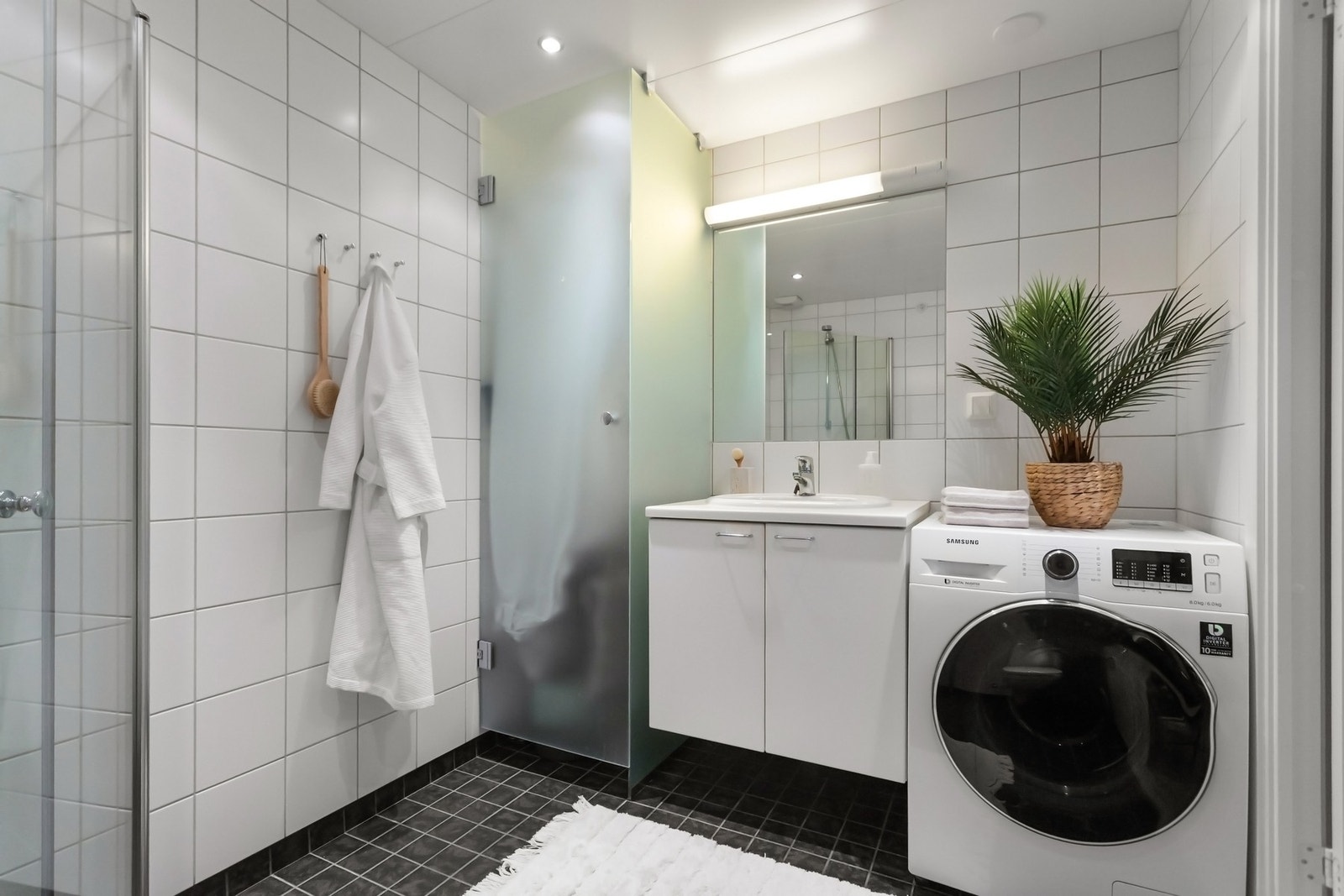 Dusjhjørne med innfellbare dusjdører for plassbesparelse og tørkeskap. Galleribilde