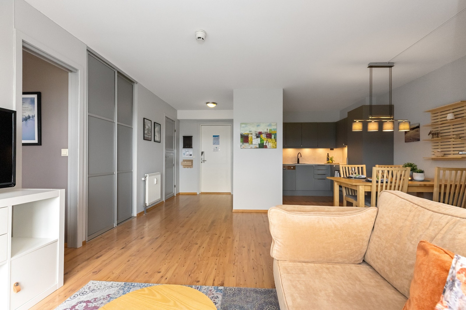 Stue- og kjøkkenløsning med soner for sofa og spiseplass Galleribilde