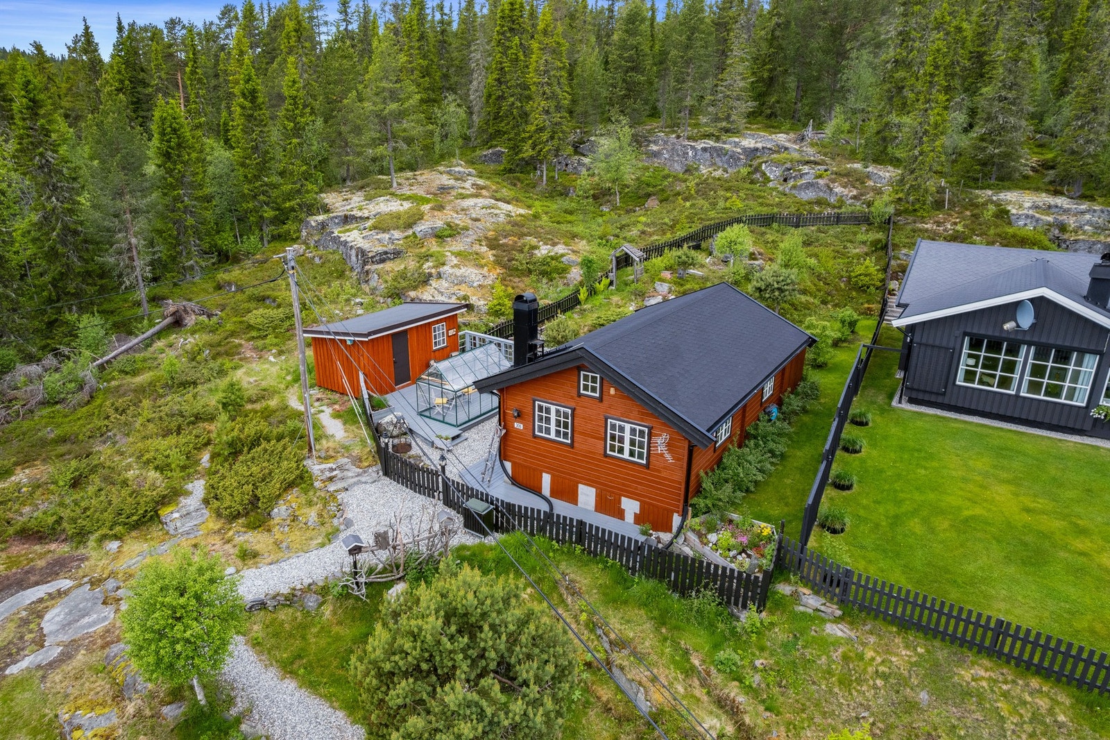 Tomten er pent opparbeidet med gruslagte gangsoner, plattinger og et herlig drivhus i glass. Galleribilde