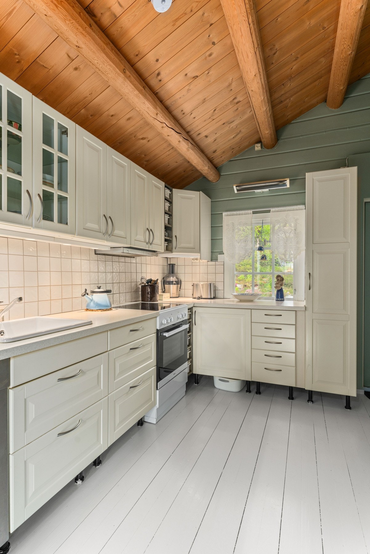 Over benkeplaten er det lagt hvite fliser som gir praktisk sprutbeskyttelse. Galleribilde