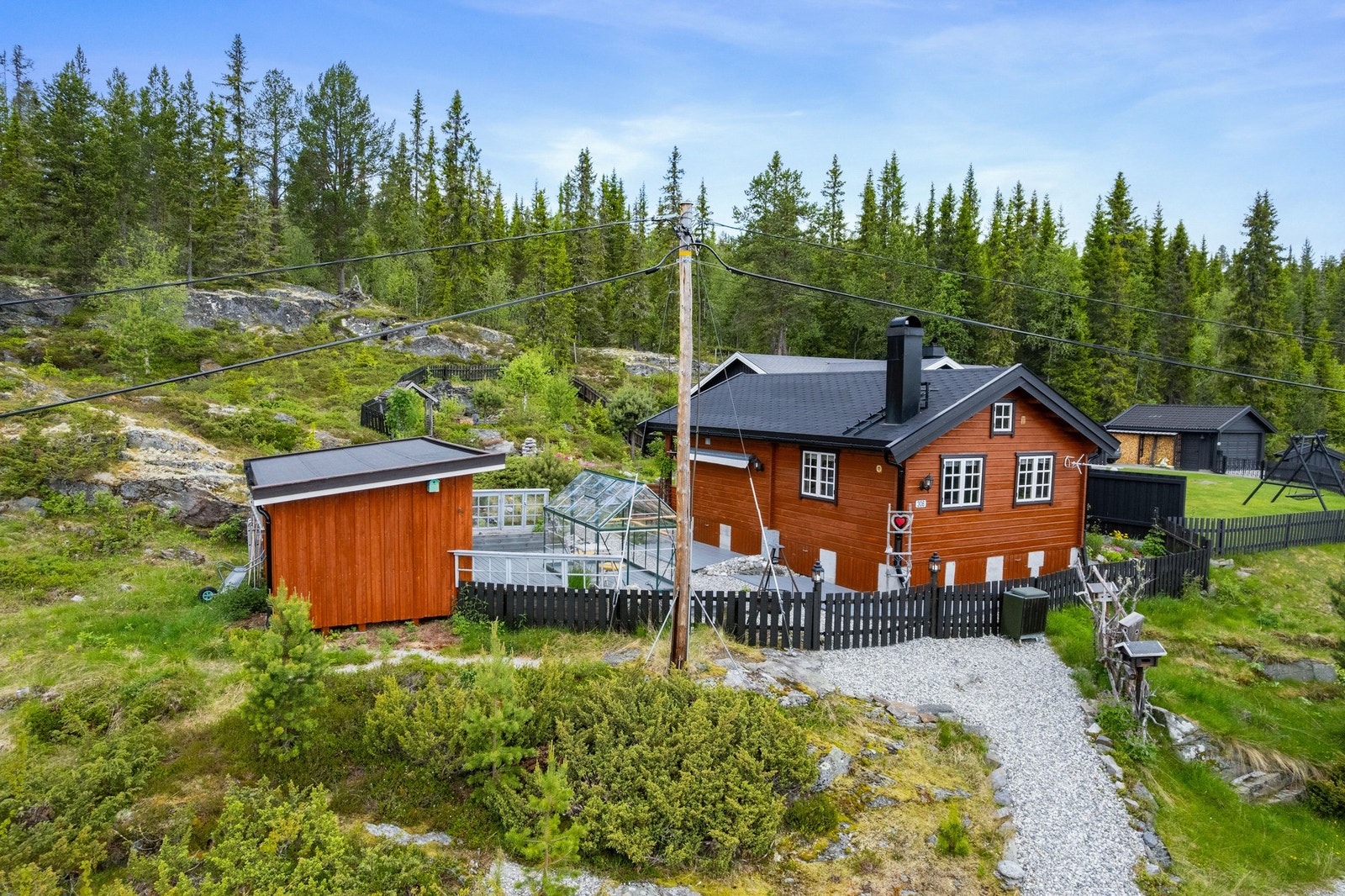 Tomten grenser til vakker natur med skog og berg i bakkant - perfekt for deg som ønsker ro, turmuligheter og et liv nær naturen. Galleribilde