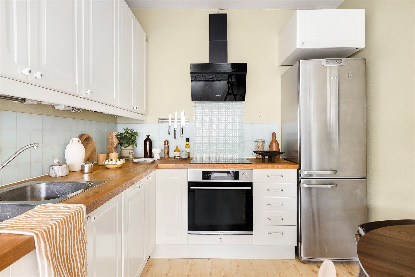 Kjøkkeninnredning med over og underskap påmontert profilerte fronter. Heltre benkeplate med nedfelt platetopp og kum Galleribilde