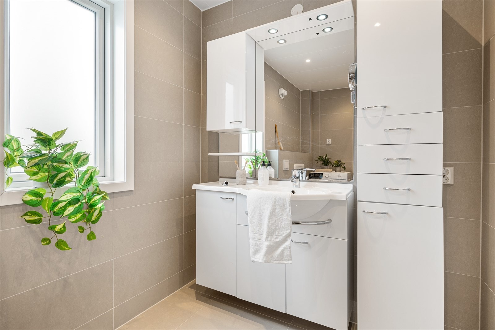 På badet er det kermaiske fliser på gulv og vegger, takplater i himling og innfelte spotter. Galleribilde